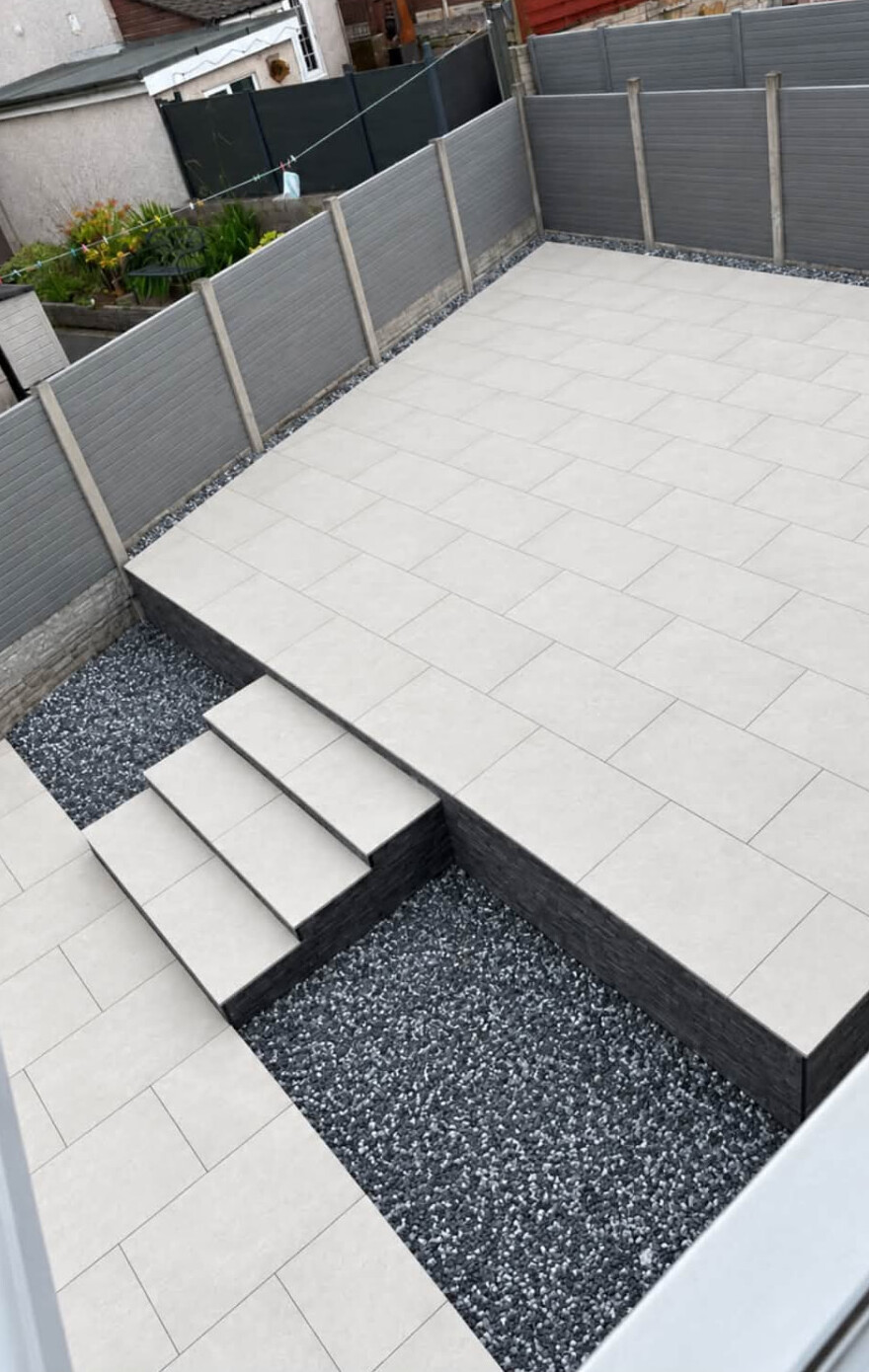 Modern raised porcelain patio with steps, built by Next Level Gardens in Carlisle