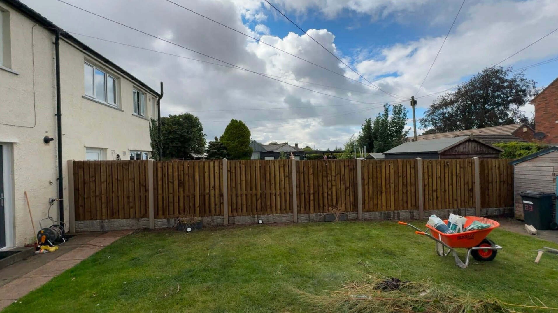 New timber panel garden fence installed along the back of a lawn