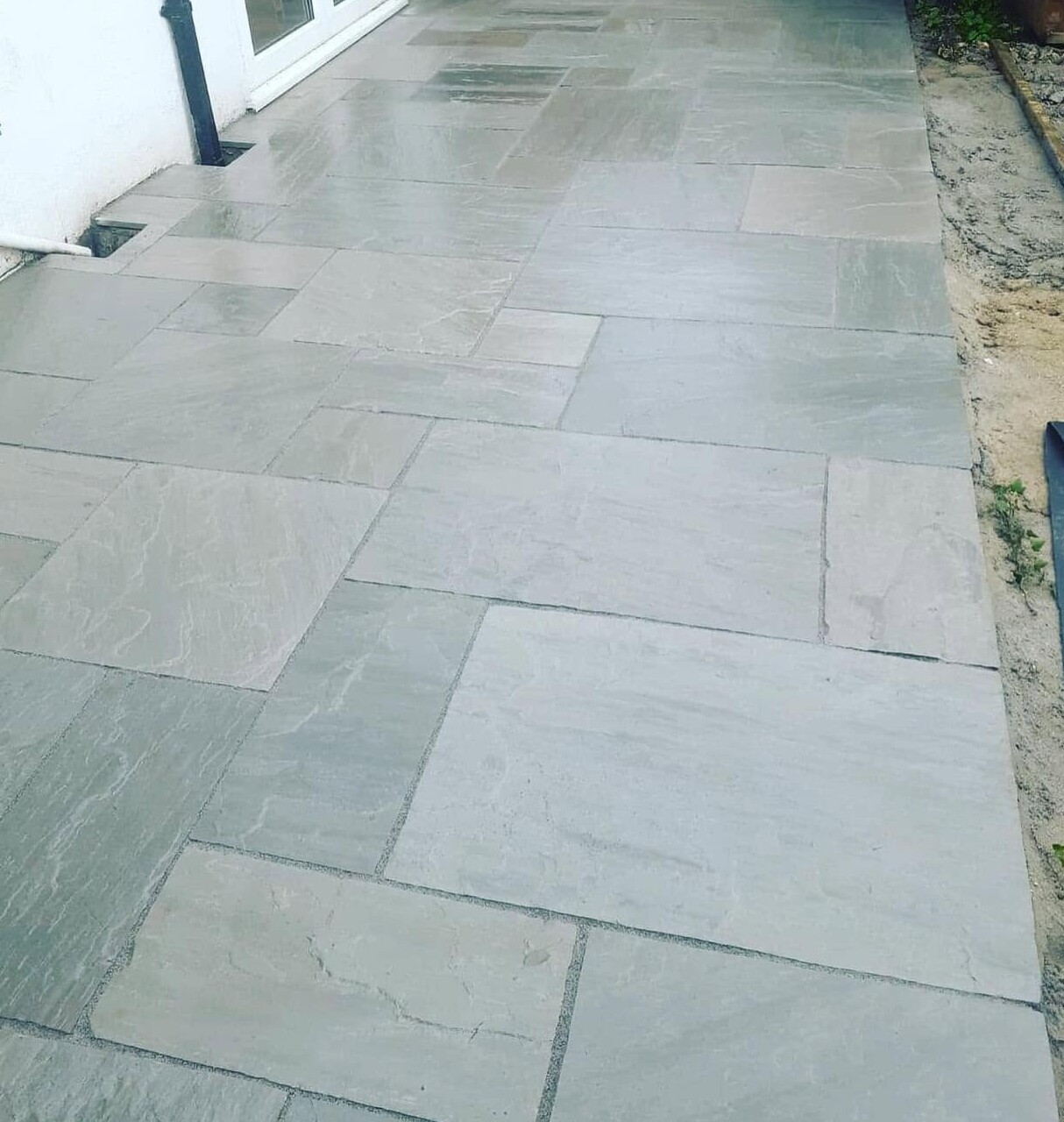 Light grey natural stone paving laid beside a house in Carlisle
